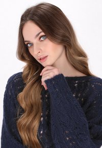 Marine gebreide trui met intrikate kantpatronen, textuurgarens en brede mouwen. Beschikt over een losse pasvorm en een ronde halslijn, die zachte vezels benadrukt.