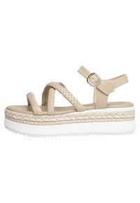 Sandali platform beige con cinturini incrociati, adornati con borchie, dotati di una zeppa in juta intrecciata e di una suola in gomma bianca.