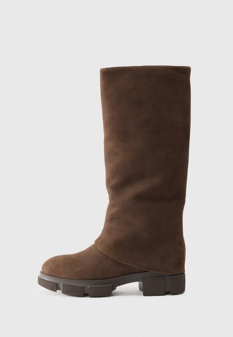 Ruskosuede polvivarreiset saappaat, joissa on pyöreä kärki, paksu lohkoheitto ja pehmeä, hieman ryppyinen rakenne. Ei näkyvää metalliosaa tai kuvioita.