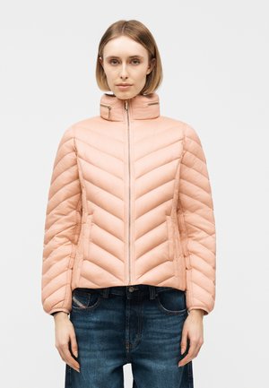 Γυναίκα που φοράει ανοιχτό ροζ μπουφάν με επένδυση, ψηλό γιακά, και φερμουάρ μπροστά, με σκούρο μπλε τζιν, στέκεται μπροστά σε απλό φόντο.