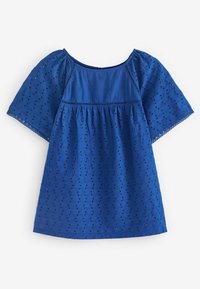 Top in cotone blu con maniche corte, caratterizzato da motivi a occhio tagliati e vita arricciata. Collo rotondo e superficie testurizzata.