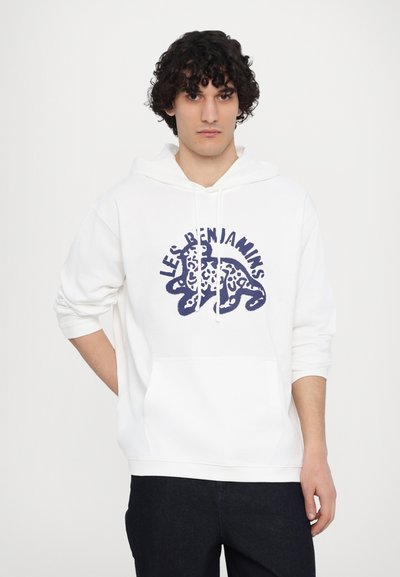 White hoodie with a front kangaroo pocket, features a blue graphic design with "LES BENJAMINS" text and animal pattern. Soft cotton material.