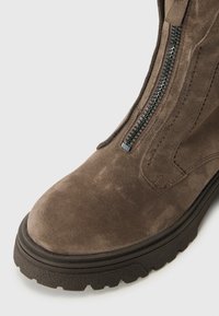 Brown suede enkellaars met een gestructureerde afwerking, een rits aan de zijkant en een robuuste rubberen zool met een stevig profiel.