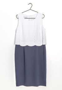 Mouwloze jurk met een witte top met golvende kantafwerking en een marineblauwe rok, gemaakt van een soepele stof met een relaxte pasvorm.