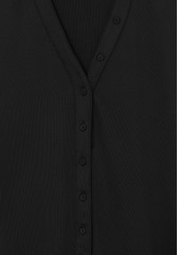 Black blouse featuring a V-neck, buttoned front, and smooth texture. The fabric is lightweight with a matte finish and no visible patterns.