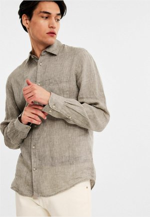 Gray linen long-sleeve shirt with a buttoned placket, front pocket, and rounded hem. Features a relaxed fit and subtle texture.