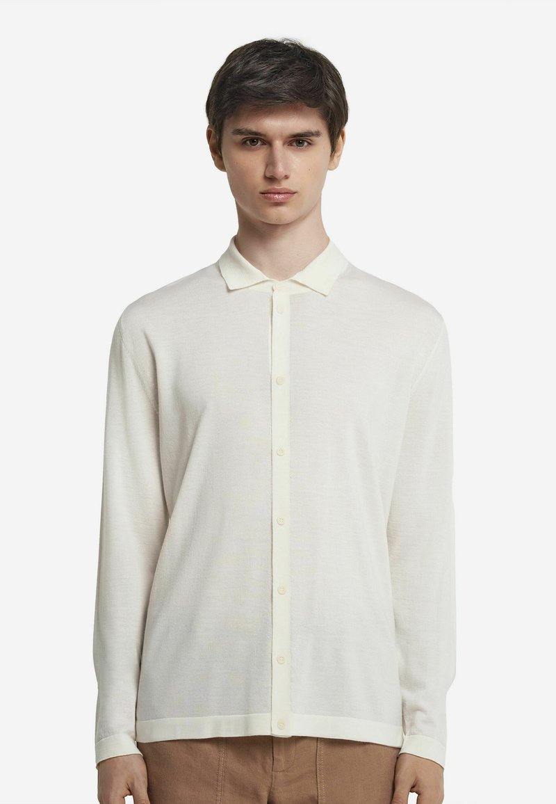 Långärmad skjorta med knappar i off-white, tillverkad av lättviktsmaterial, med en mjuk krage och rak nederdel samt manschetter vid ärmarna.