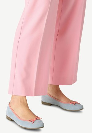 Lyseblå ruskinds ballet flats med en lyserød kant og sløjfedetalje, parret med brede lyserøde bukser, der viser en glat tekstur.