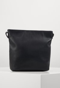 Czarna skórzana torba o fakturowanej powierzchni. Miękki, prostokątny kształt z dwoma bocznymi uchwytami. Minimalistyczny design, bez widocznych metalowych elementów ani zdobień.