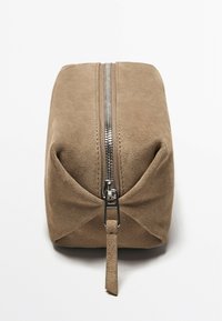 Sacca in suede beige con forma rettangolare, zip argentata lungo la parte superiore e un piccolo tirante sul davanti. Texture liscia, design minimal.