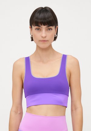 Purple sports bra with a square neckline, featuring contrasting stitching and a smooth texture. Breathing mesh design at shoulder straps.
