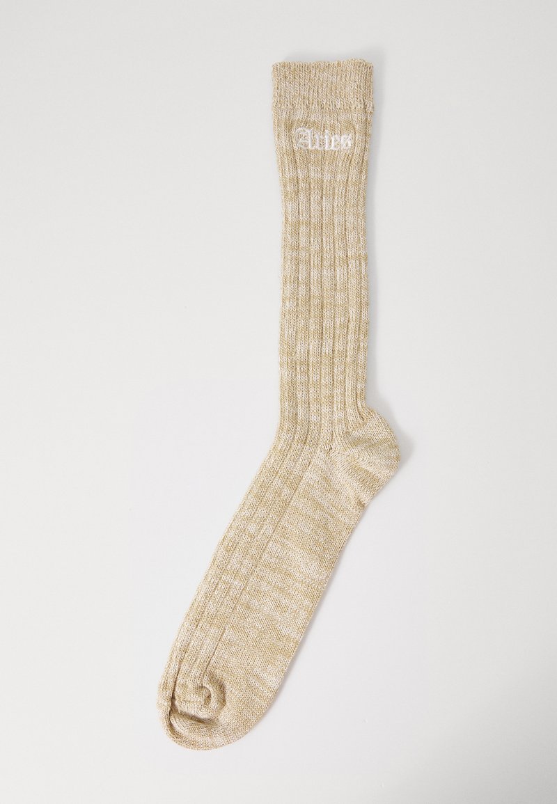 Knæhøje strømper i lys beige med ribbet tekstur. Har hvidt broderet logo øverst og en rund tådesign.