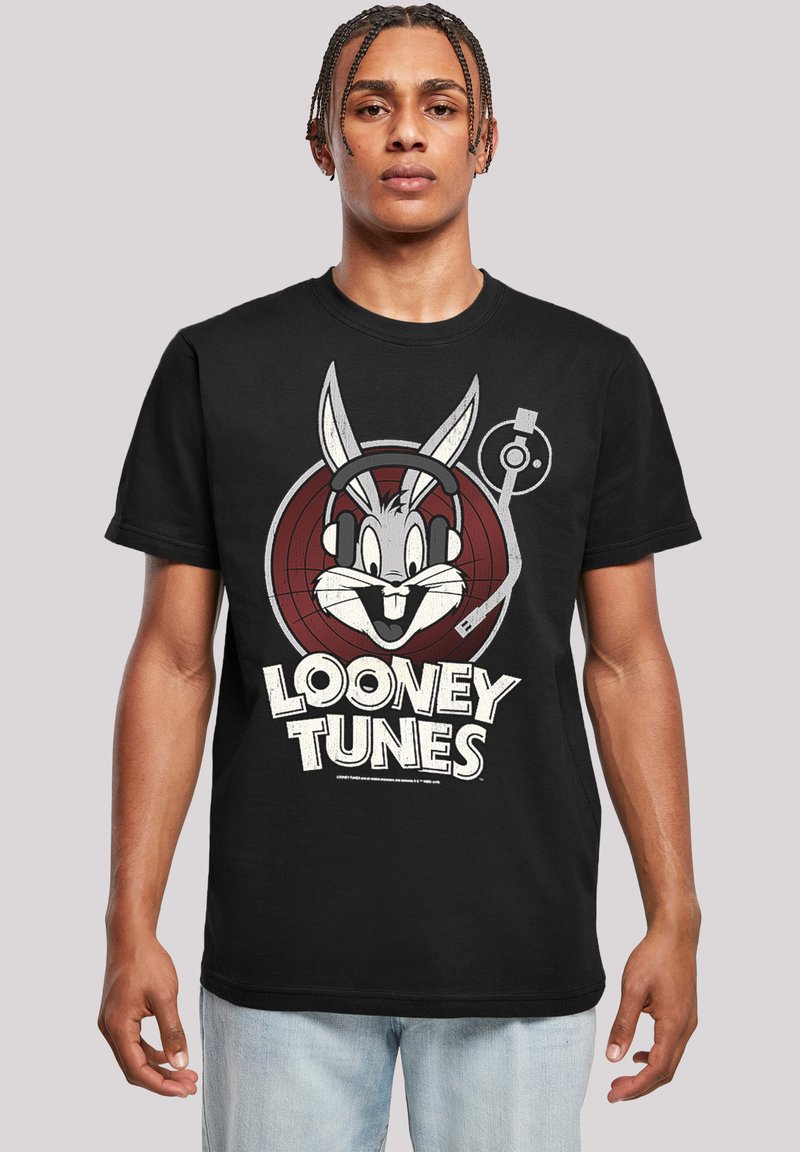 Melnas kokvilnas T-krekls ar grafiku, kurā attēlots Bugs Bunny ar austiņām, centrēts sarkanā mērķī, un balts teksts "LOONEY TUNES" zem tā.