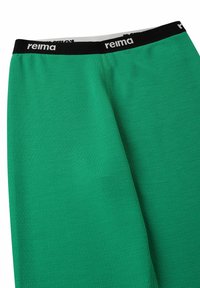 Zielone legginsy wykonane z teksturowanej tkaniny; posiadają czarny elastyczny pas z logo 'reima'; dopasowany krój.