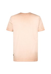 Světle broskvové triko s krátkým rukávem s gradientním efektem, měkkou texturou a malým logem na dolním levém rohu.