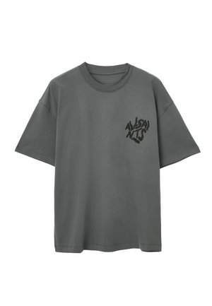 Szara bawełniana koszulka z okrągłym dekoltem, krótkimi rękawami i czarną grafiką na lewej stronie klatki piersiowej. Charakteryzuje się luźnym krojem i miękką teksturą.