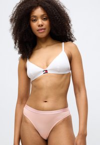 Λευκό τριγωνικό μπραλέτ με λεπτές τιράντες και κεντρική λεπτομέρεια λογότυπου. Συμβαδιστά ροζ ψηλόμεσα σλιπάκια με λογότυπο στη μέση. Απαλή ύφανση.