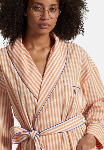Szlafrok w pomarańczowo-białe paski, z kołnierzem szalowym, niebieskim obszyciem, wiązaniem w talii oraz kieszenią na piersi z detalem logo.