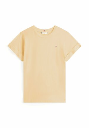 T-shirt à manches courtes et col rond en coton doux jaune pâle. Présente un petit logo sur la poitrine gauche et des manches à revers.