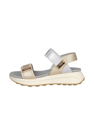 Sandalia abierta beige y plateada con dos correas ajustables, plantilla acolchada y suela blanca gruesa con exterior marrón texturizado.