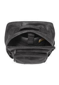 Sac à dos en cuir noir avec un rabat supérieur, des compartiments intérieurs et une poche zippée à l'avant. Surface texturée et poignées robustes.