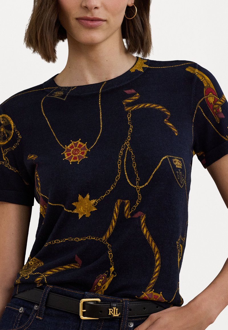 Granatowa koszulka z dzianiny z wzorami w złote i czerwone łańcuchy oraz emblematy, z prążkowanym dekoltem, krótkimi rękawami i dopasowanym krojem.