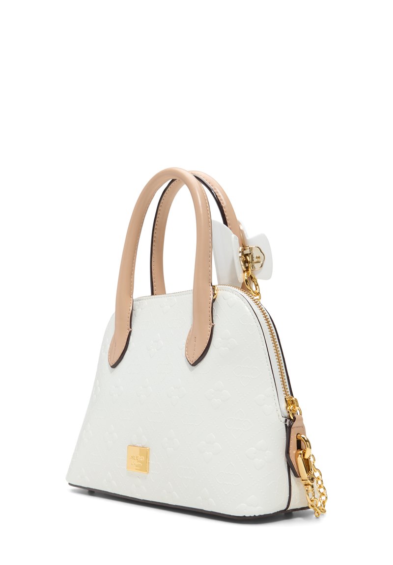 Sac à main en cuir blanc avec des accents beiges, fermeture éclair, doubles poignées, quincaillerie dorée et motif de nœud embossé sur la surface.