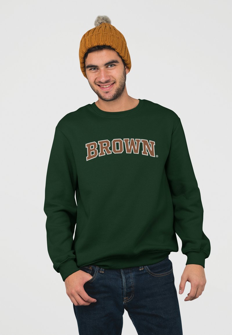 Sweatshirt vert foncé avec le texte "BROWN" en beige, col rond côtelé et poignets, associé à un jean bleu foncé et un bonnet en tricot orange.