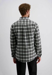 Grijs en wit geruit overhemd met lange mouwen, met knoopmanchetten, een spread collar en een gebogen zoom, van achteraf gezien.
