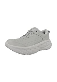 Zapatilla deportiva gris con parte superior texturizada, sistema de cordones prominente, suela acolchada y suela de goma con patrón de olas.