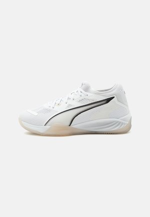 Hvid atletisk sneaker med mesh-overdel, sort sideliste, snørelukning og gennemsigtig sål, vist fra siden på en lys baggrund.