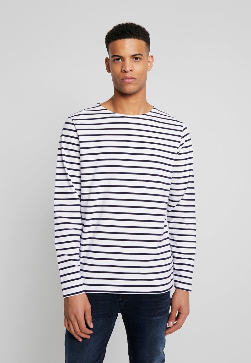 Camicia a maniche lunghe bianca con righe orizzontali blu marina, con scollatura a girocollo e una vestibilità rilassata. Tessuto morbido al tatto, design informale.