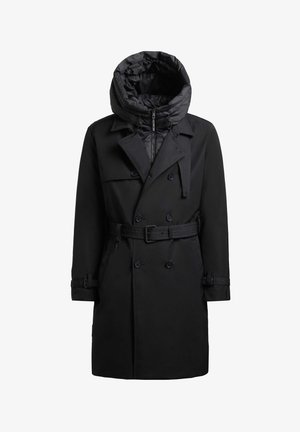 Manteau noir en trench avec une capuche rembourrée amovible, devant double boutonnage, ceinture et poignets ajustables. Fabriqué en tissu lisse et résistant à l'eau.
