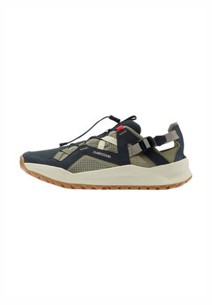 Olivegrüner und schwarzer Hiking-Sneaker mit niedrigem Schaft, Mesh-Einsätzen, verstellbarem Riemen, Schnell-Schnürsystem und Gummisohle.