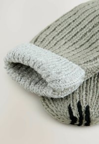 Gorro de punto gris con un puño acanalado doblado en gris claro y rayas horizontales negras. Textura suave, forma redonda y costura detallada.