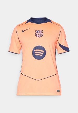 Maillot orange à manches courtes avec des accents bleu marine, logo de Barcelone et un grand logo circulaire noir de Spotify sur le devant. Tissu texturé.