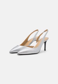 Escarpins argentés à paillettes avec des pointes et des talons stiletto noirs. Doublure intérieure lisse avec talons ouverts pour un enfilage facile.