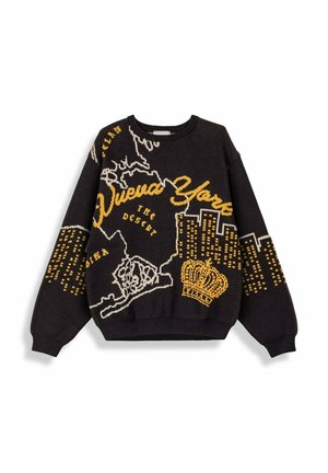 Jersey negro con diseños amarillos y blancos que incluyen texto de Nueva York, silueta de la ciudad, contorno del mapa y una corona en la parte delantera y las mangas.