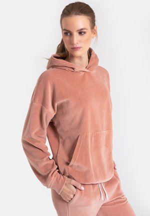 Różowy welurowy hoodie z kieszenią na froncie, długimi rękawami i kapturem z możliwością regulacji. Miękka tekstura, luźny krój i minimalistyczny design.