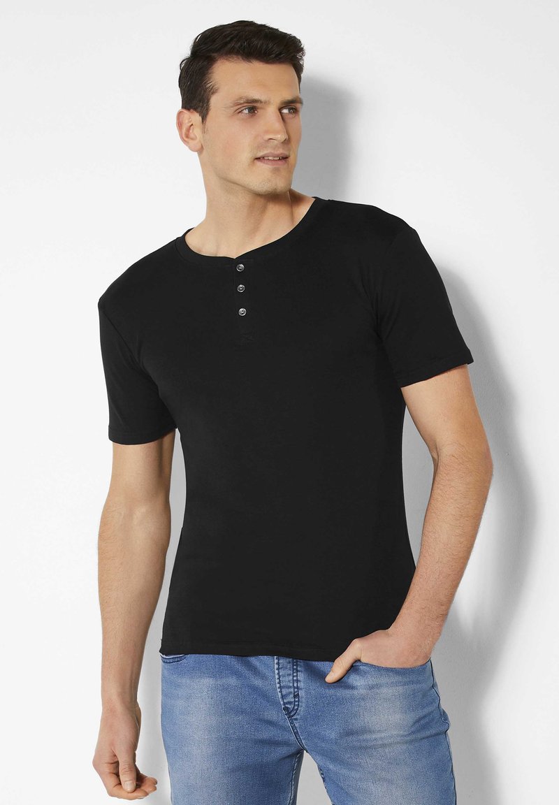 Schwarzes T-Shirt mit kurzen Ärmeln, rundem Hals und einer Knopfleiste mit drei Knöpfen. Aus weichem Stoff gefertigt, figurbetontes Design, minimale Nähedetails.