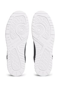 Λευκές σόλες παπουτσιών από καουτσούκ με ανάγλυφα σχέδια πέλματος και κυκλικά σχέδια, με το λογότυπο "HILFIGER" σε κάθε σόλα.