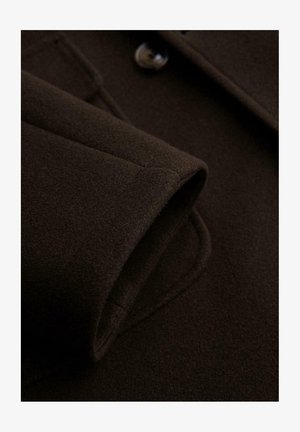 Dunkelbrauner Wollstoff mit einem gefalteten Bündchen und einem Knopfdetail. Die Textur ist weich und dicht, mit sauberen Nähten und einer glatten Oberfläche.