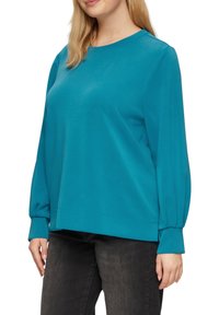 Tüm tür, weiches Sweatshirt in Türkis, mit langen Ärmeln und gerafften Bündchen, sowie einem lockeren Schnitt. Einfacher Rundhalsausschnitt, ohne Muster.