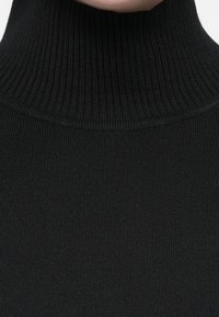 Jersey de cuello alto negro con ribetes, que presenta un cuello alto y un diseño de punto texturizado, proporcionando una apariencia lisa y ceñida al cuerpo.