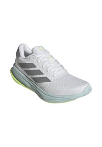 Zapatilla deportiva blanca con parte superior de malla texturizada, diseño de tres franjas grises, suela verde menta y sutiles acentos en amarillo neón.