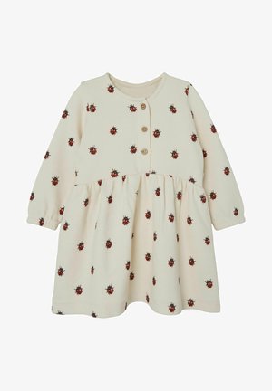 Robe pour tout-petit à manches longues couleur crème avec petits imprimés de coccinelles rouges et trois boutons en bois à l'avant.