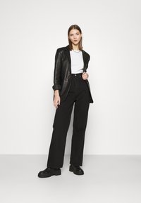 Levi's® HIGH LOOSE - Calças de ganga à boca de sino - black denim