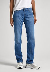 Vaqueros de mezclilla azul claro con un diseño de pierna recta, que cuentan con un estilo de cinco bolsillos, cierre delantero de botón y costuras en contraste.