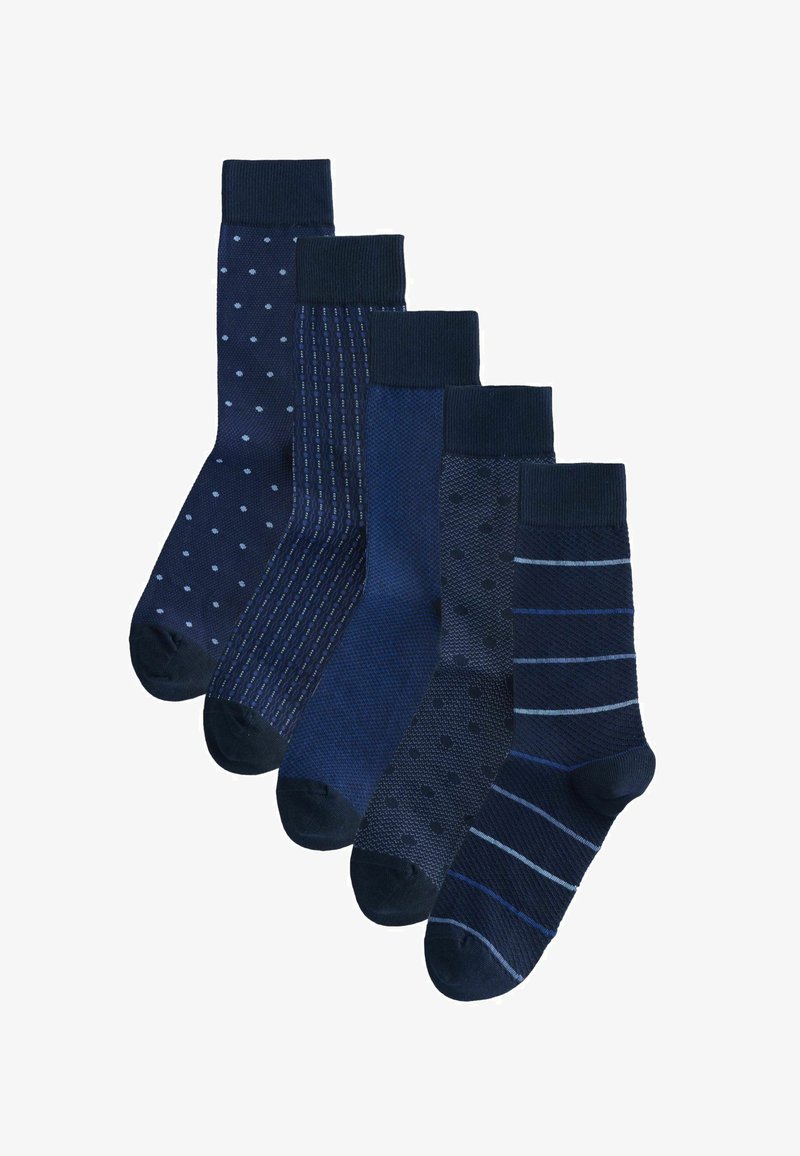 Cinq paires de chaussettes bleu marine avec des motifs variés, y compris des pois, des rayures et des designs texturés, disposées en une rangée décalée.