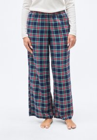 Παντελόνι πιτζάμας με καρό σχέδιο και ελαστική μέση, με μοτίβο σε μπλε, κόκκινο και πράσινο, φαρδιές μπατζάκια και απαλό ύφασμα.